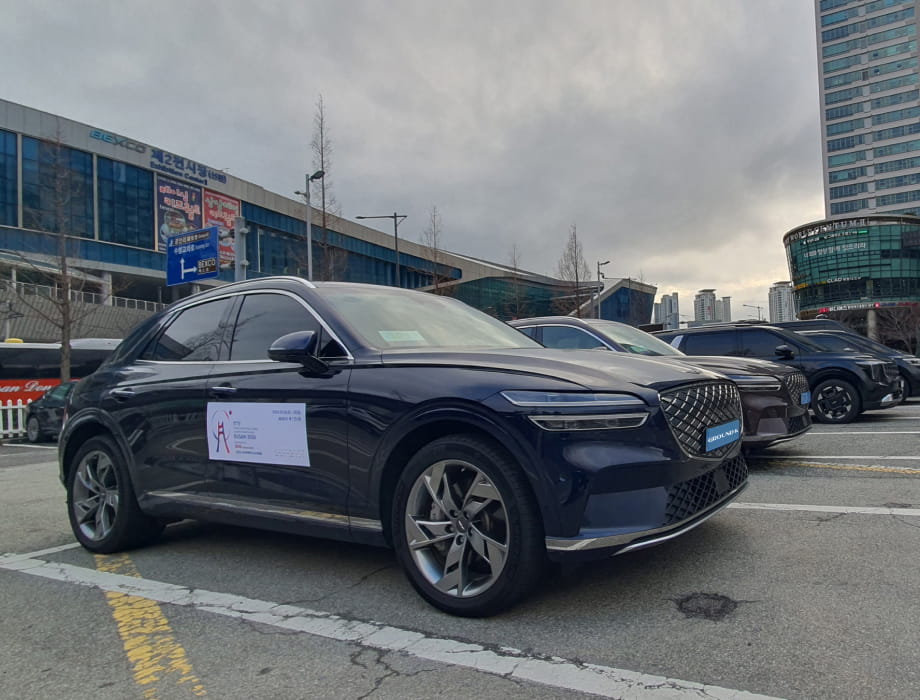 Black protocol vehicles parked in a row with 2024 Busan World Table Tennis Championships posters attached.