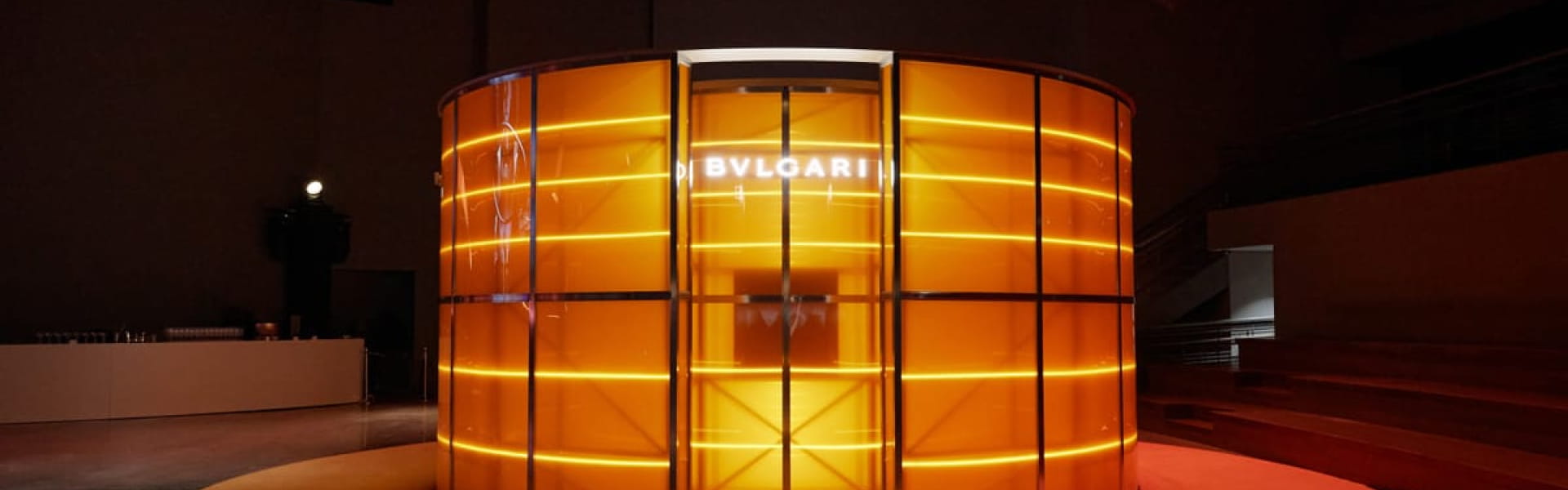 Bvlgari exhibition display with illuminated orange panels.