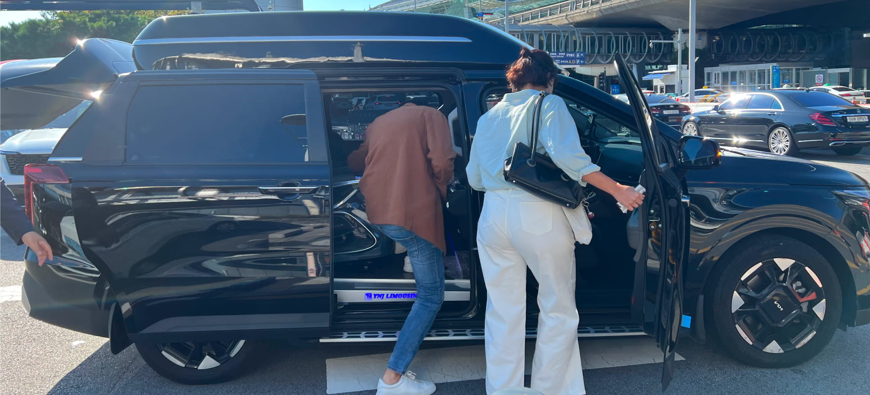Guests boarding a premium black Kia Carnival limousine with professional assistance for the 2024 Seoul International Drama Awards.
