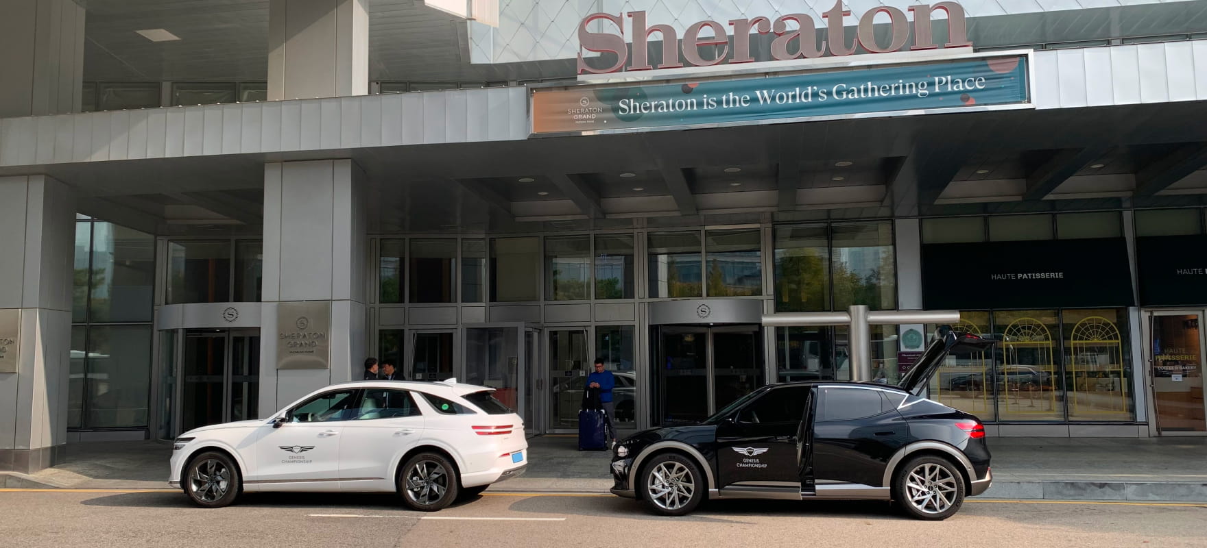 White Genesis GV70 and black GV60 providing premium protocol and shuttle services at the Sheraton hotel main entrance.