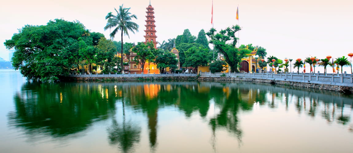 Reflective view of Tran Quoc Pagoda on Hanoi’s lake, ideal for cultural and luxury tours.