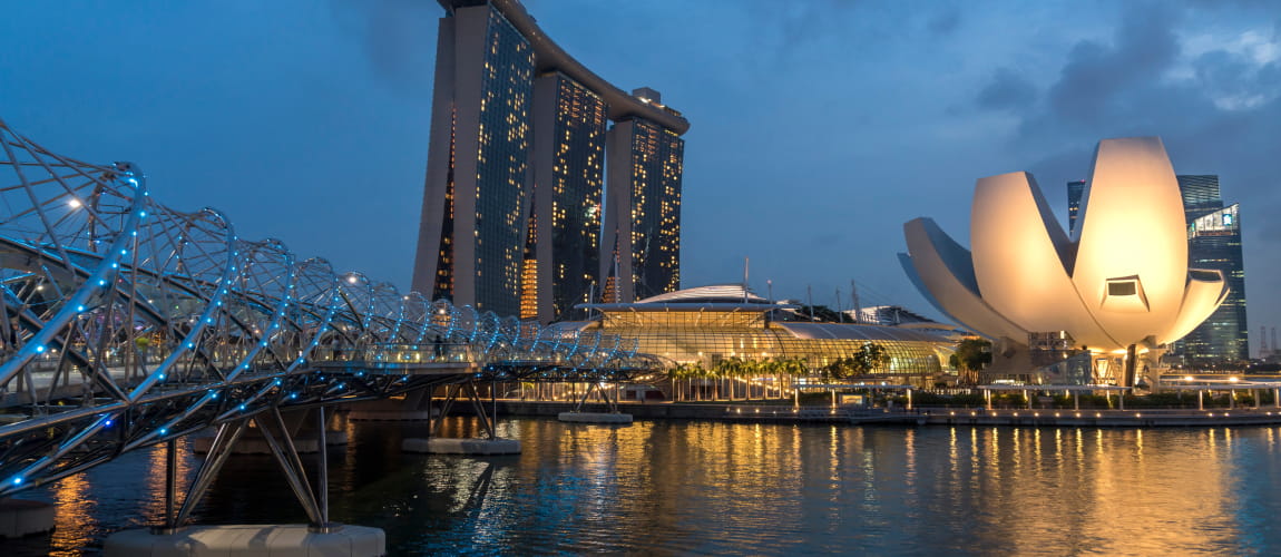 Singapore's Marina Bay Sands, ArtScience Museum, and Helix Bridge at dusk, highlighting iconic architecture and luxury travel.