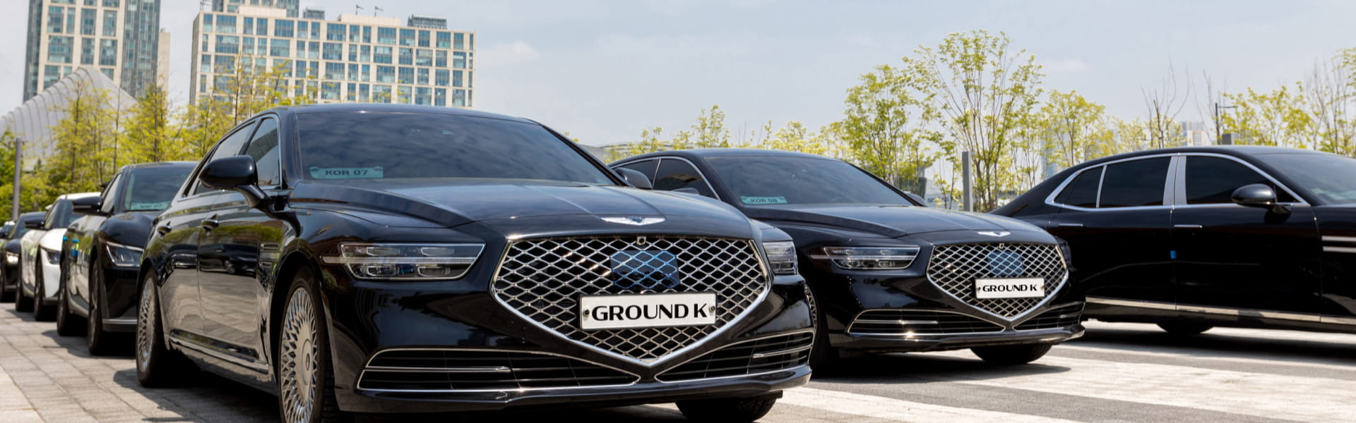 Genesis G90 cars with GroundK license plates parked side by side.